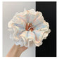 Blue plaid lace trim scrunchie styled on a wrist with soft lighting