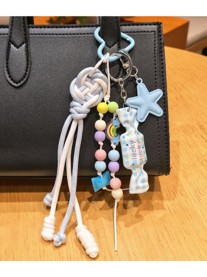 Blue star candy keychain hanging from a set of keys on a wooden surface
