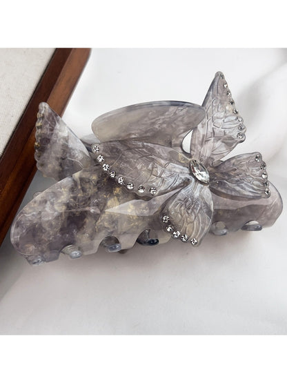 Beau colorful butterfly hair claw clip photographed with soft shadows