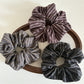 Close-up of Gifty elegant dark striped scrunchie on white background