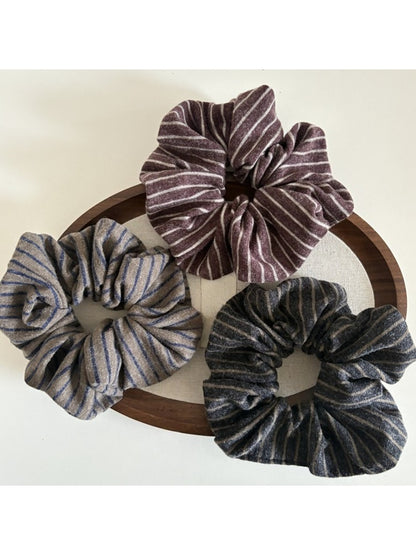 Close-up of Gifty elegant dark striped scrunchie on white background
