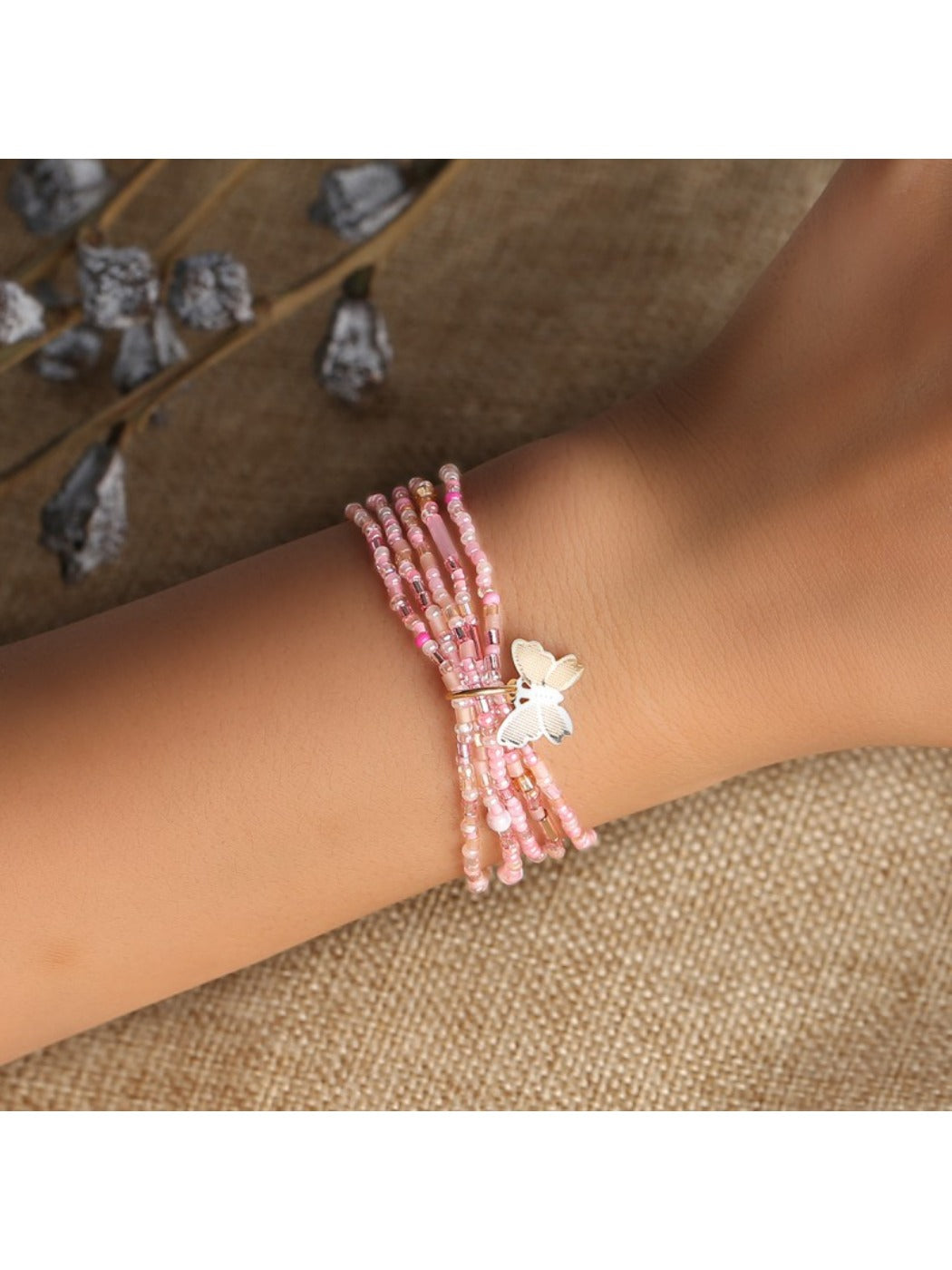 Lovra minimalist multi strand bracelet with small beads and butterfly charm on wrist