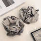 Close-up of Gifty polished neat look scrunchie in soft beige fabric