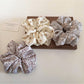 Gifty scrunchie styled on a wrist showing floral pattern and gathered fabric texture