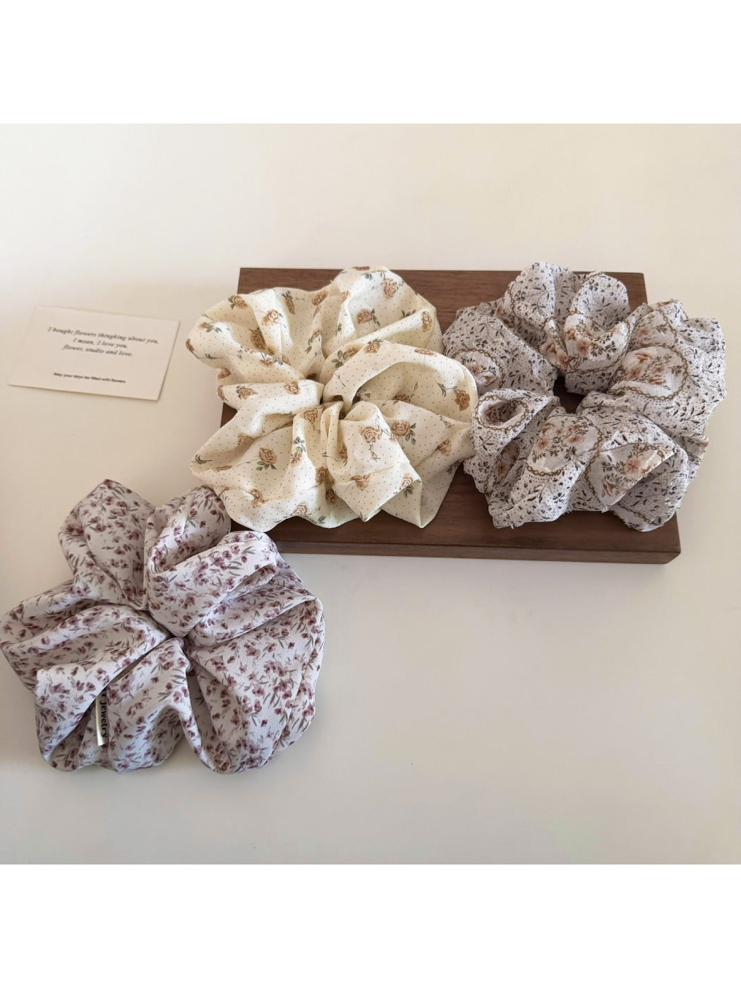 Gifty scrunchie styled on a wrist showing floral pattern and gathered fabric texture