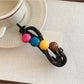 Side view of Beau colorful round bead bar hair clip in styled hair