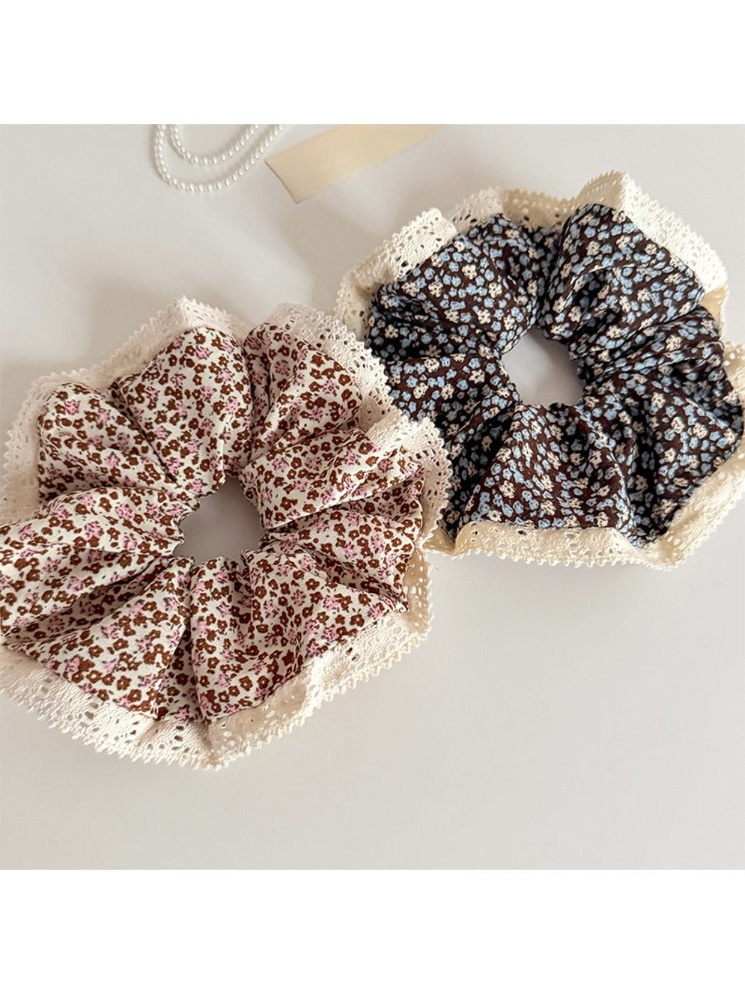 Gifty scrunchie with delicate floral lace trim displayed on a white background