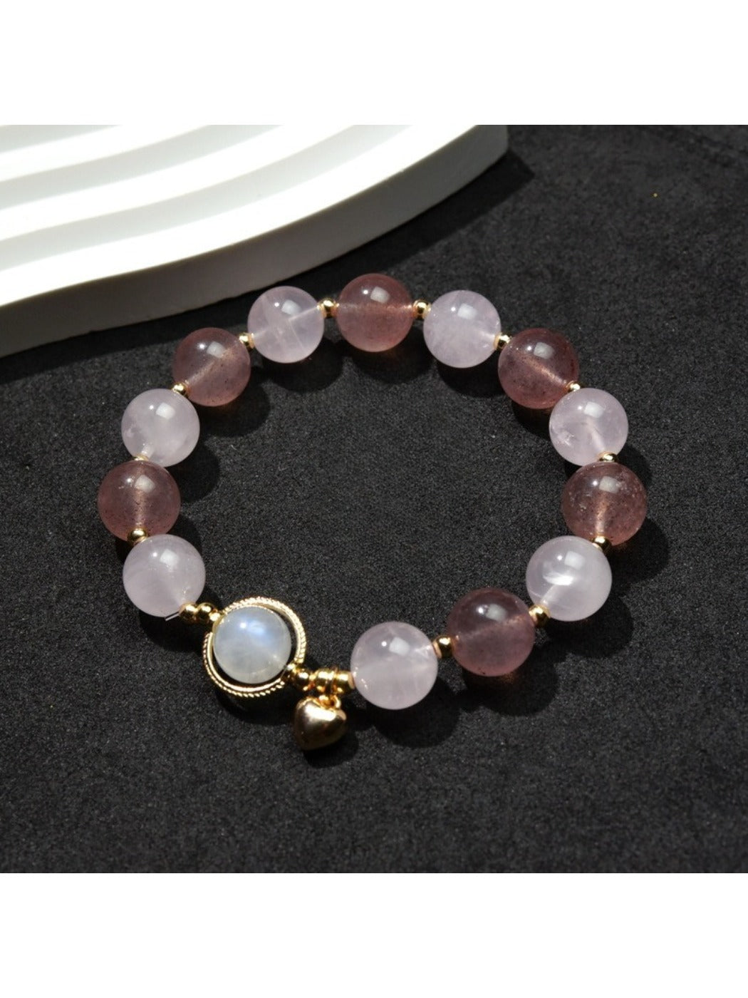 Close-up of Lovra heart pendant with small round beads on bracelet