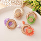 Earedge raffia daisy stud earrings displayed on a wooden surface