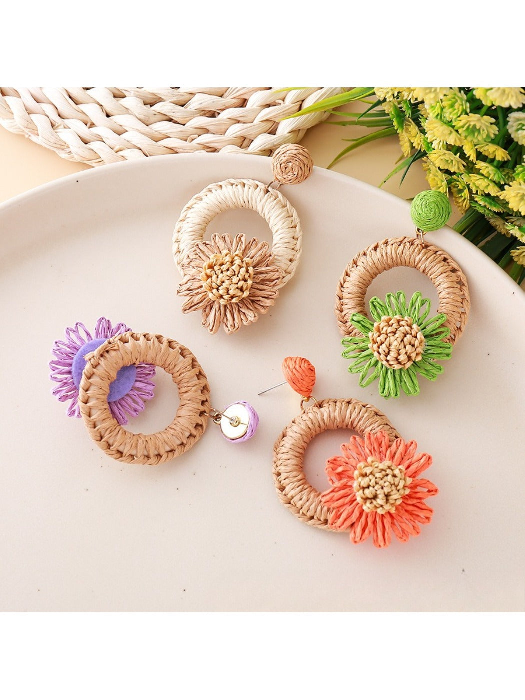 Earedge raffia daisy stud earrings displayed on a wooden surface