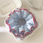 Close-up of Gifty polka dot ruffle scrunchie showing fabric texture and pattern