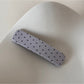 Beau hair clip held near face to show scale and design details