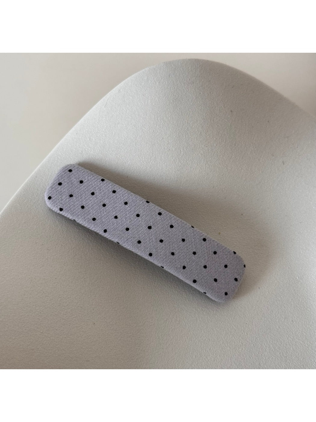 Beau hair clip held near face to show scale and design details