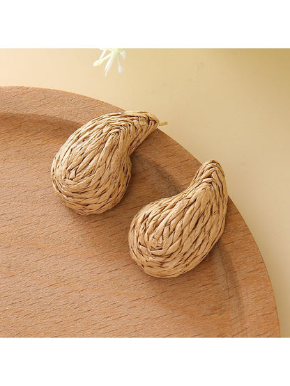 Earedge raffia water drop shaped stud earrings worn on a model's ear