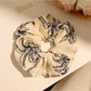Scrunchie worn on wrist showing tropical coconut tree print