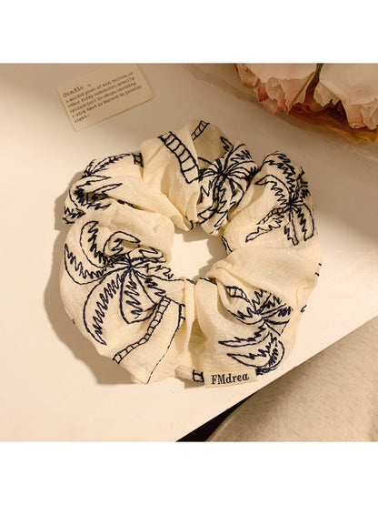 Scrunchie worn on wrist showing tropical coconut tree print