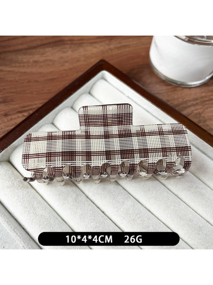 Beau plaid updo claw clip resting on a wooden surface