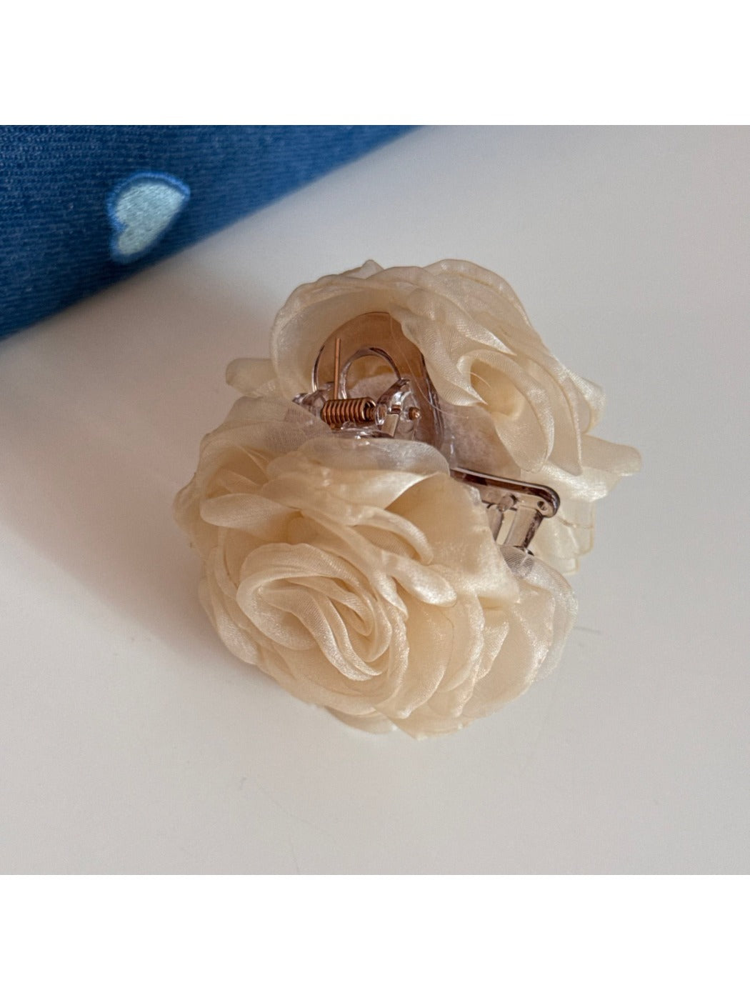 Beau rose hair clip attached to brown hair in a styled look