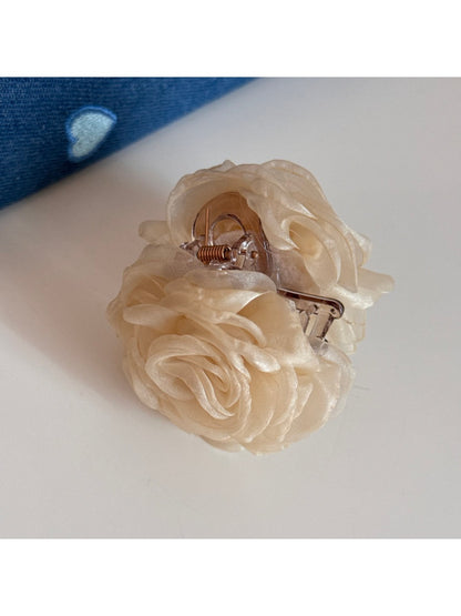 Beau rose hair clip attached to brown hair in a styled look