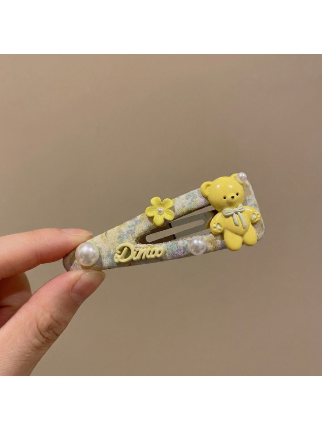 Side view of yellow tiny floral hair clip showing metal clip mechanism