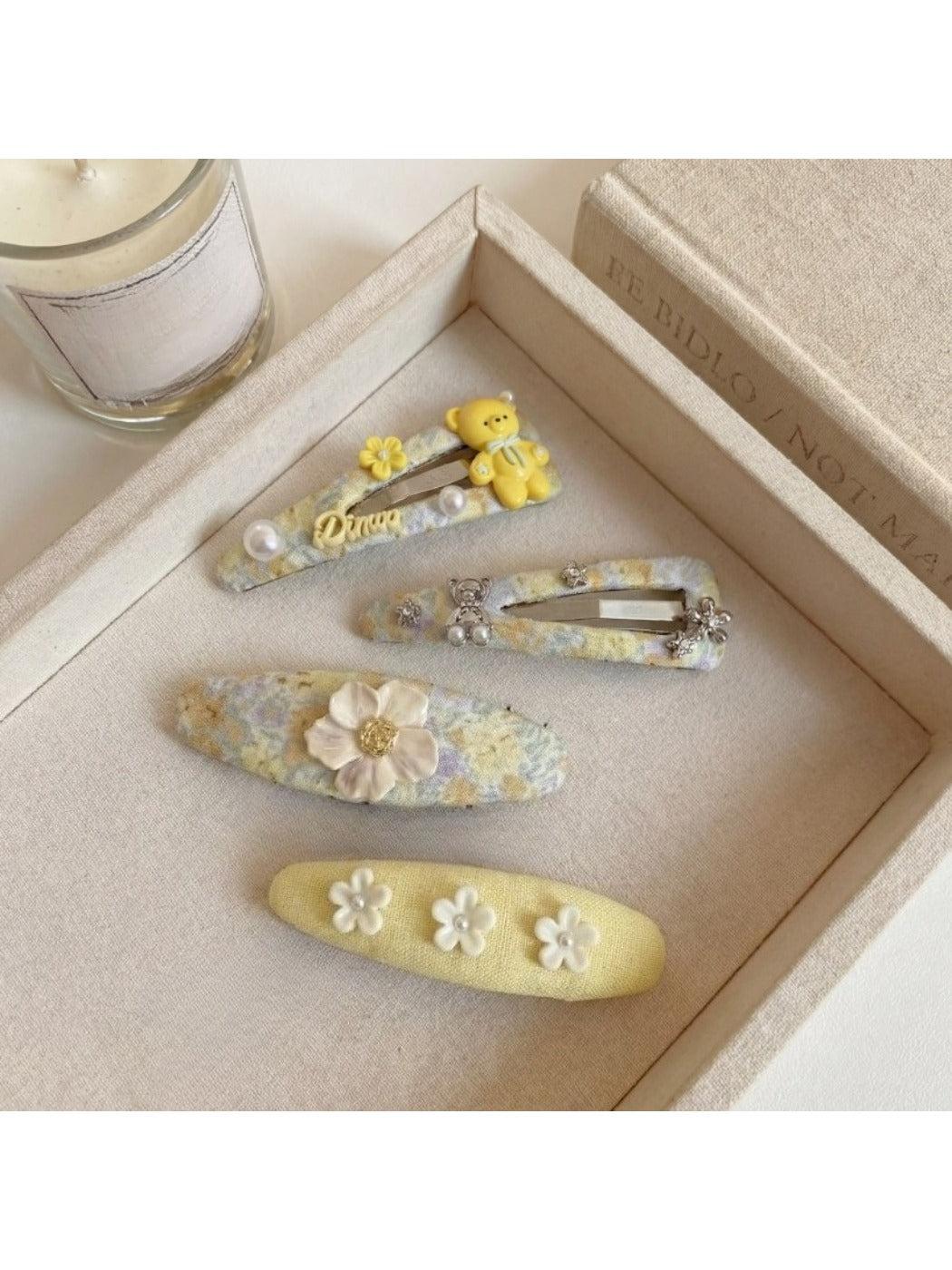 Yellow floral hair clip displayed on a white surface highlighting its curved shape