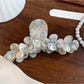 Beau claw clip with floral design shown open to reveal inner clasp