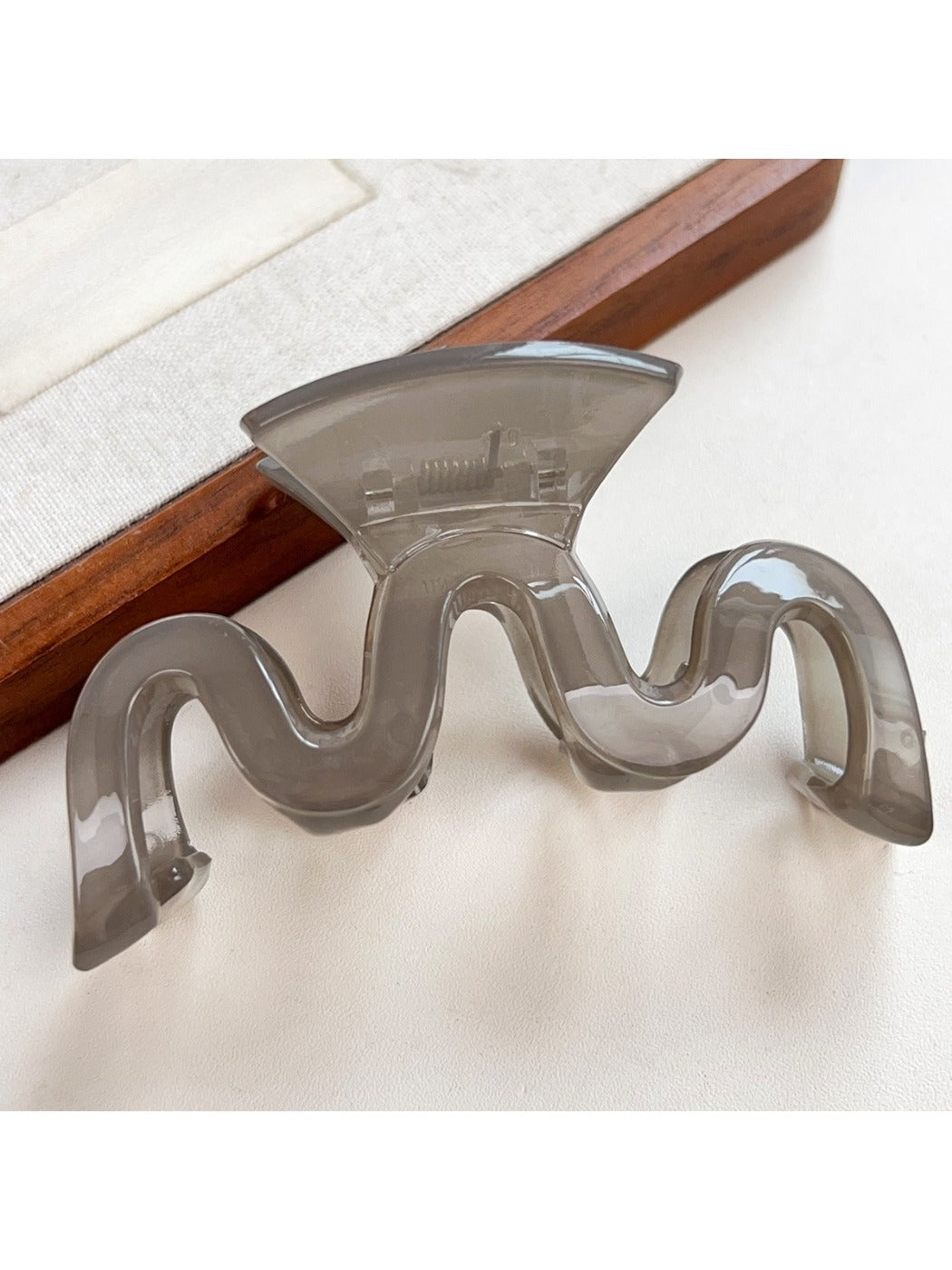 Beau wave-shaped hair claw clip in matte black with soft shadows