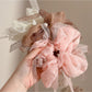 Gifty scrunchie styled on a wrist showing bow detail and gathered fabric