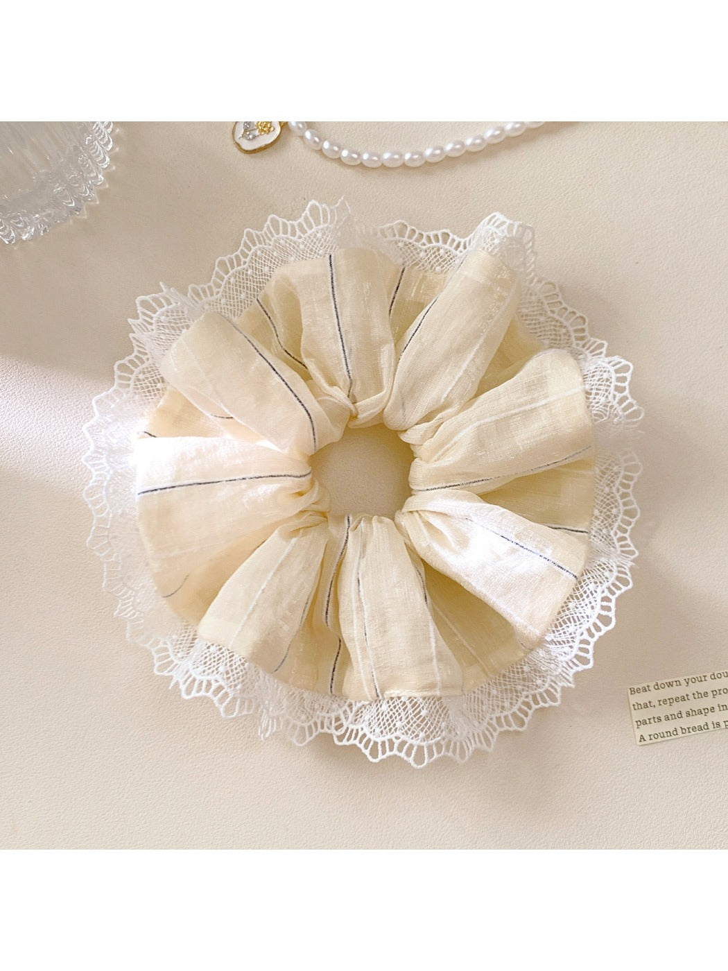 Flat lay of Gifty striped ruched scrunchie on a neutral background