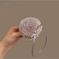 Chic hair tie with a large white flower embellishment on a black elastic band