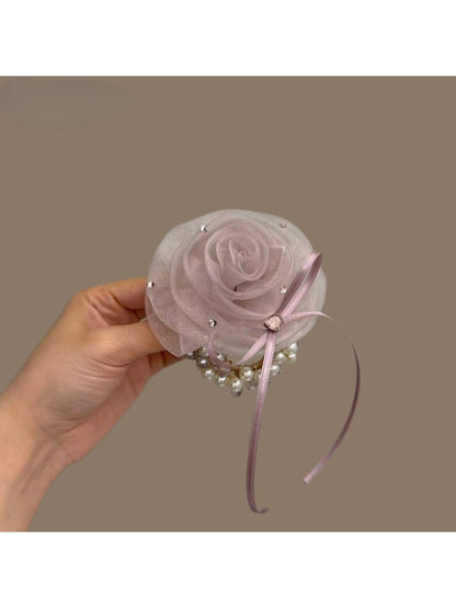 Chic hair tie with a large white flower embellishment on a black elastic band