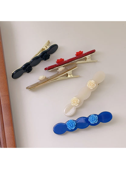 Beau hair clip held in hand showing size and rose detail