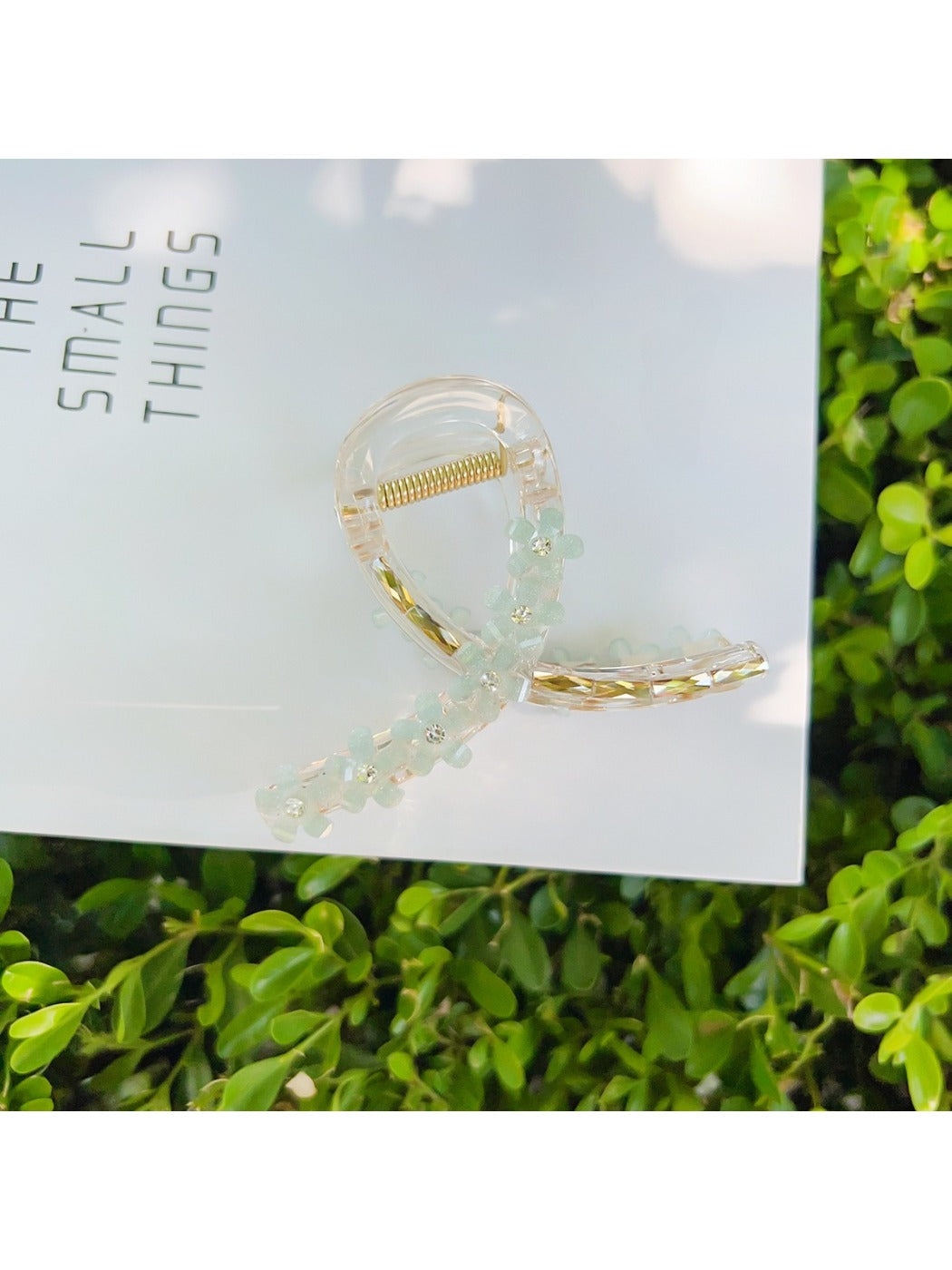 Beau flower crisscross hair claw clip next to flowers for styling inspiration