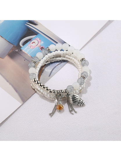 Lovra beaded bracelet displayed on a wooden surface highlighting the alloy pendant