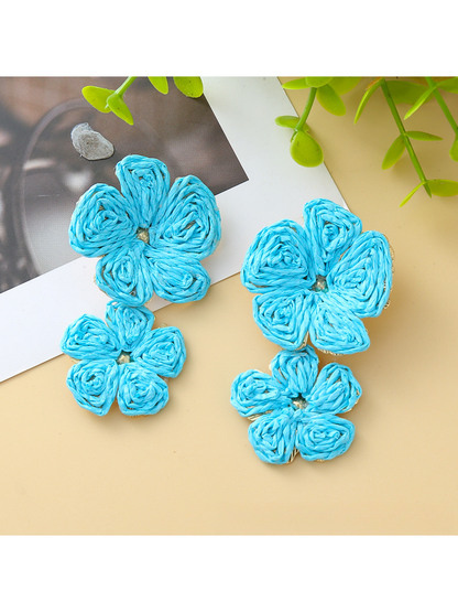 Earedge floral pendant raffia drop earrings displayed on a wooden surface