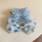 Side view of black and white polka dot bow hair tie accessory