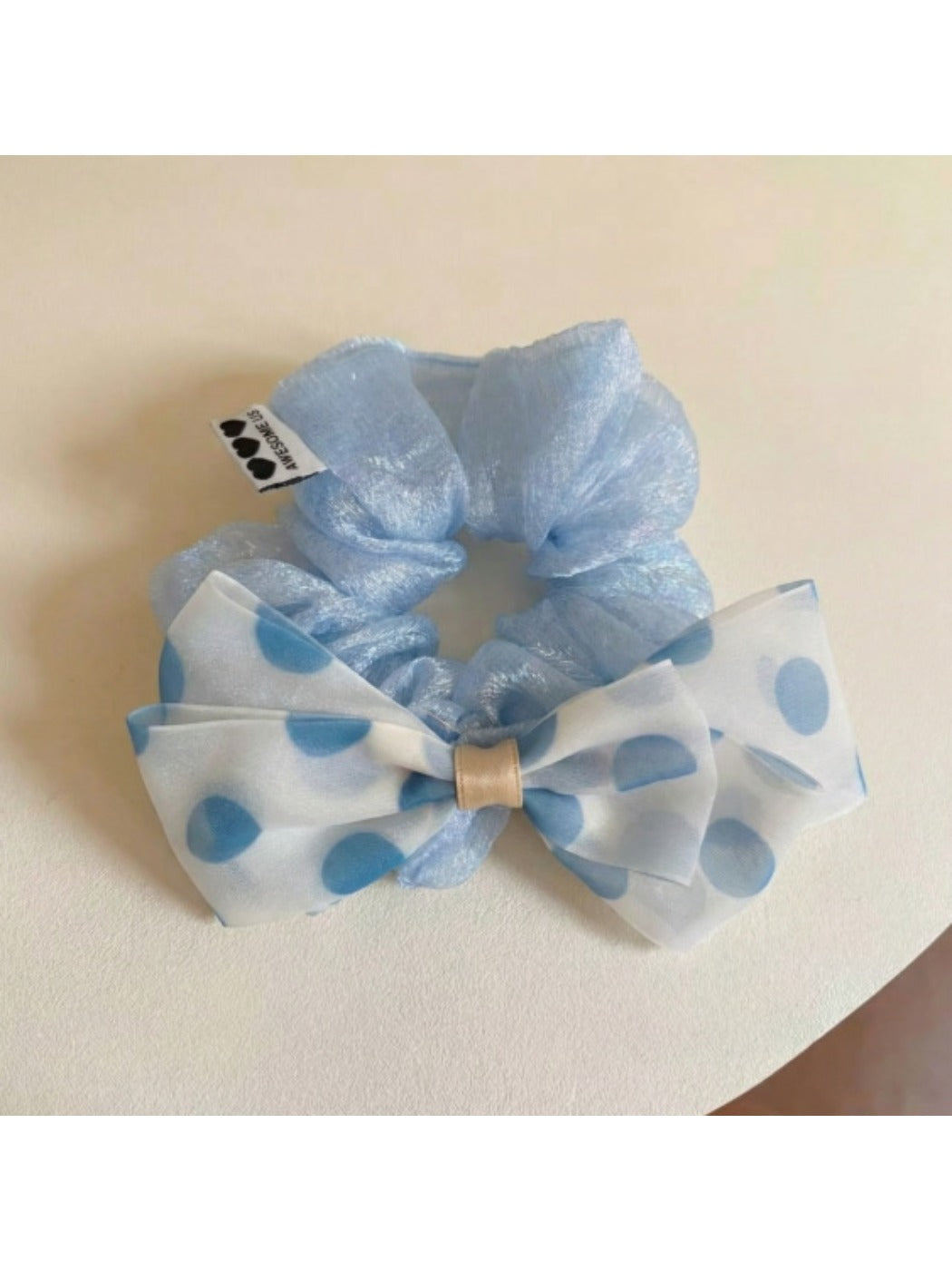 Side view of black and white polka dot bow hair tie accessory