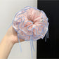 Pink scrunchie with bow pattern displayed on a white surface