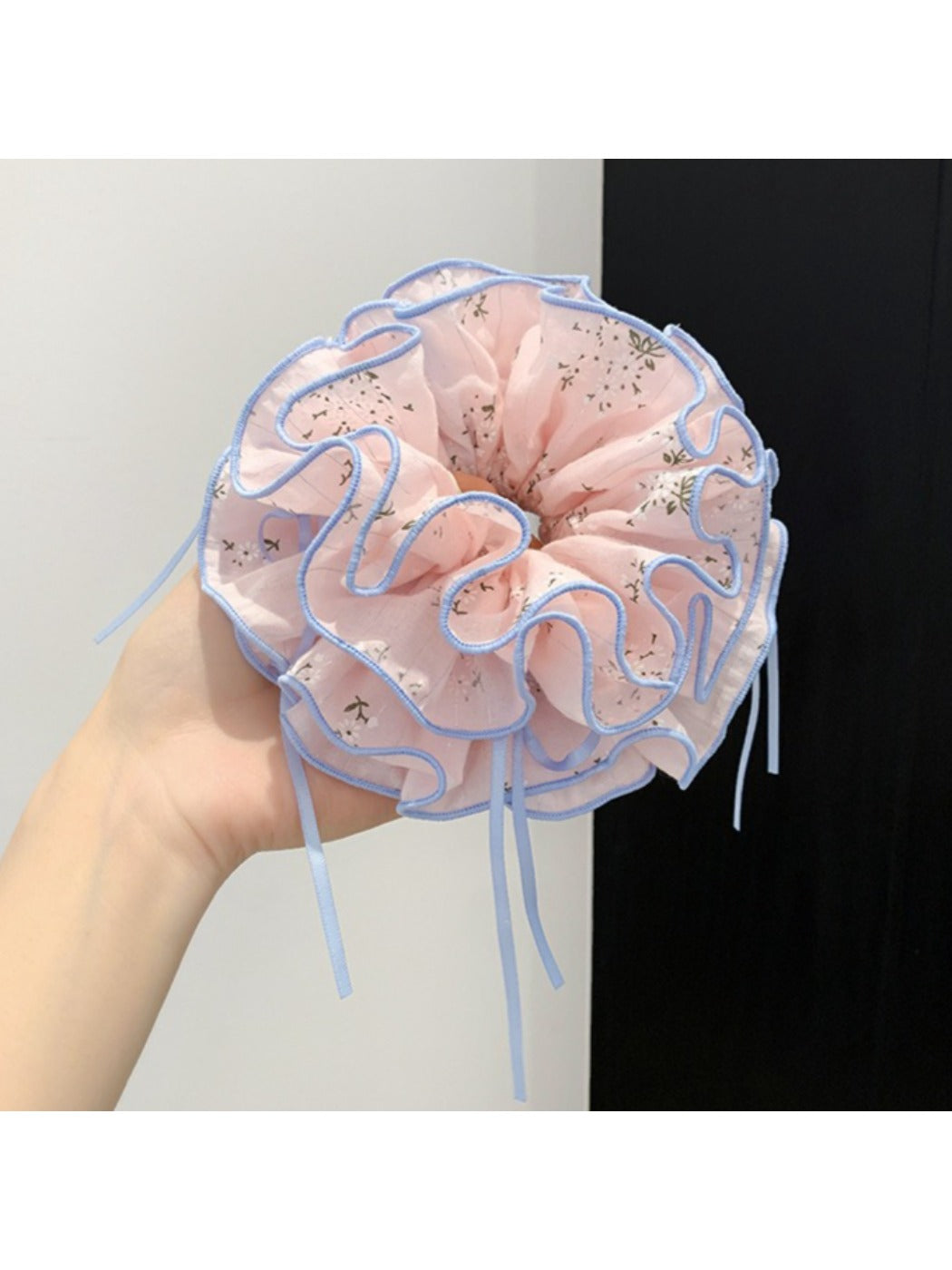 Pink scrunchie with bow pattern displayed on a white surface