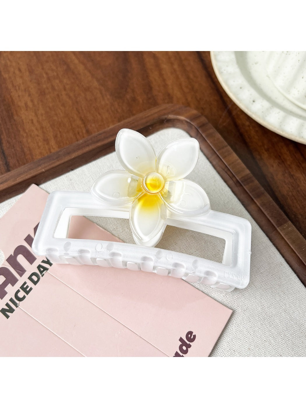 Beau square ombre flower shaped claw clip photographed with soft lighting emphasizing ombre colors