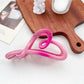 Beau ombre heart shaped bow claw clip held between fingers showing clasp detail
