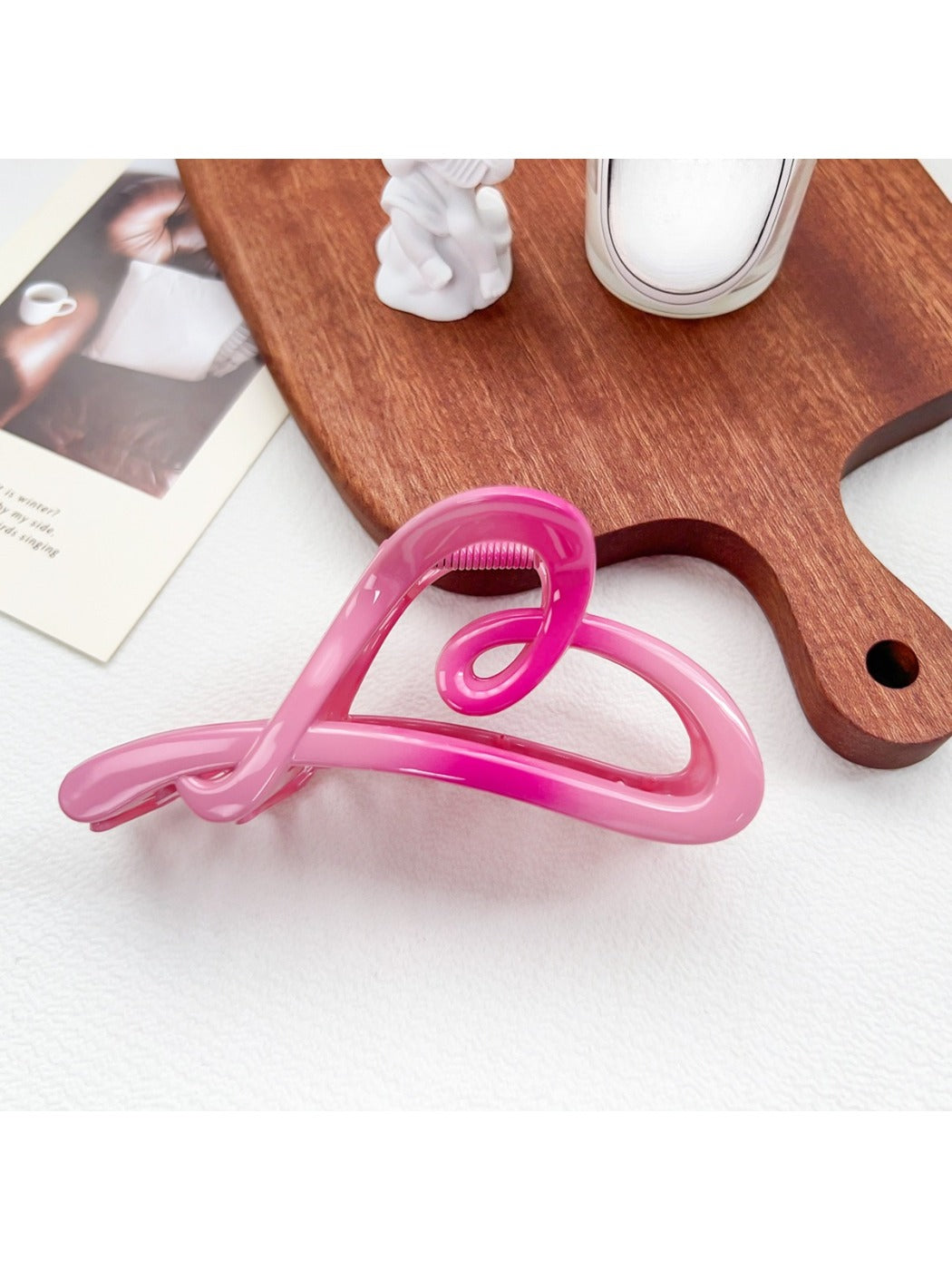 Beau ombre heart shaped bow claw clip held between fingers showing clasp detail