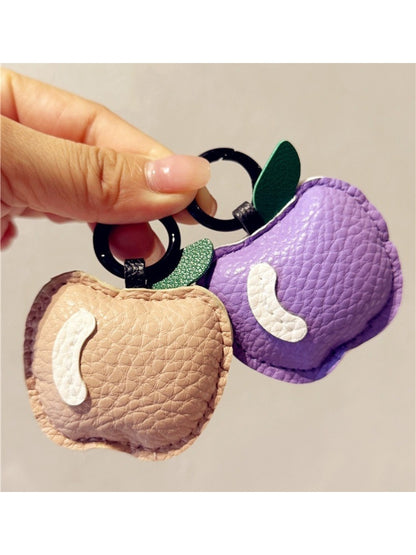Side view of small apple keychain highlighting its rounded shape and metal loop