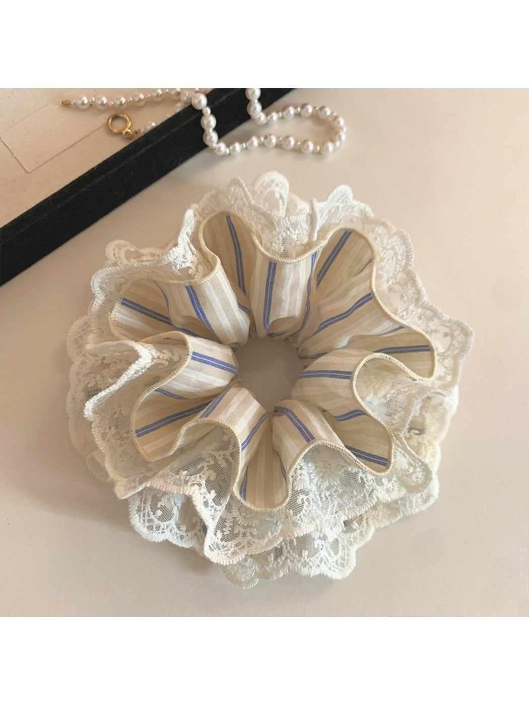 Striped lace scrunchie displayed with matching hair accessories