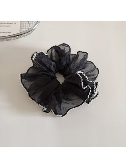 Gifty ruffled scrunchie packaged in a clear plastic bag with branding
