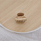 Beau medium half ponytail claw clip in neutral beige tone on wooden surface