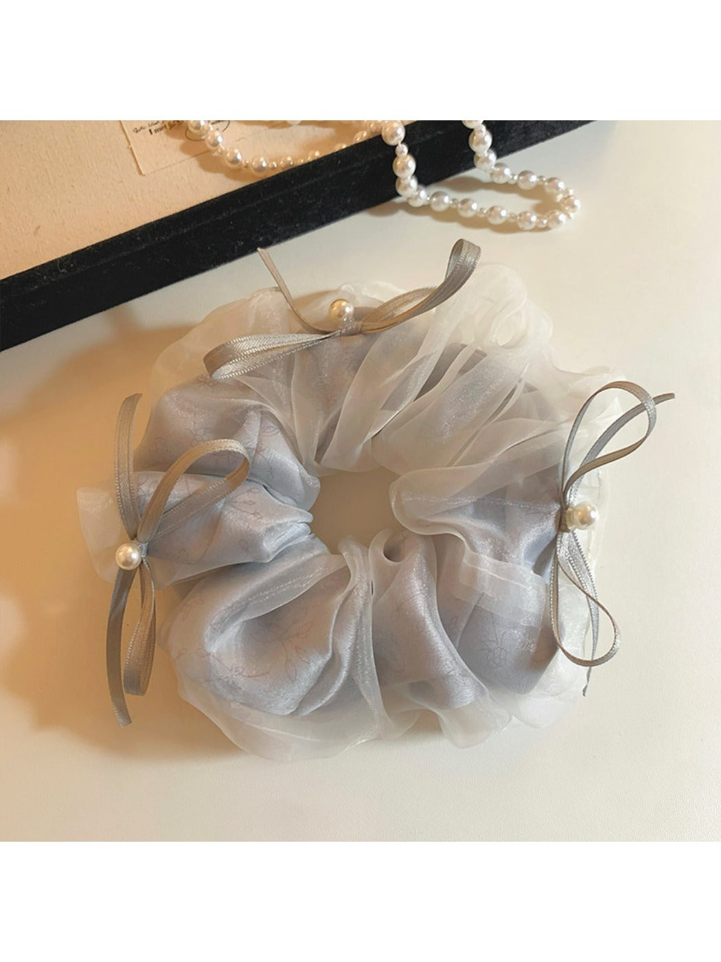 Gifty tulle ribbon bow scrunchie displayed on a wooden surface with natural light