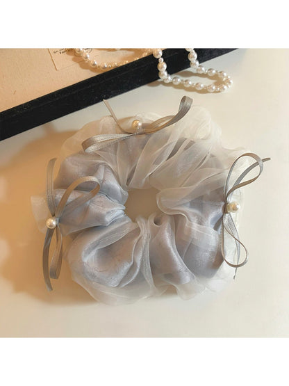 Gifty tulle ribbon bow scrunchie displayed on a wooden surface with natural light