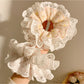 Gifty scrunchie wrapped around a ponytail in a model's hair highlighting print details