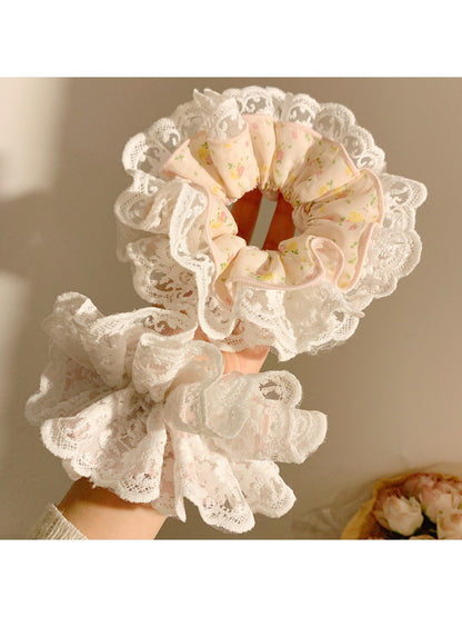 Gifty scrunchie wrapped around a ponytail in a model's hair highlighting print details